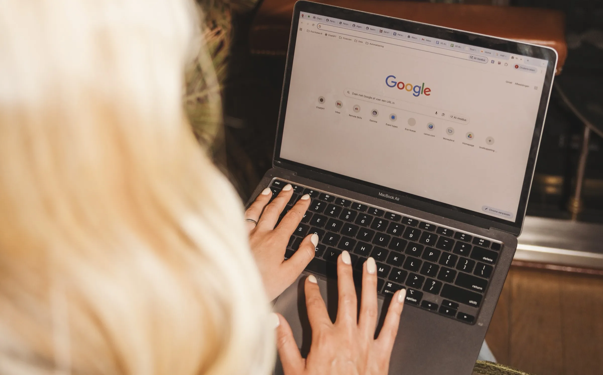 Eva typt op haar laptop, van achteren gezien